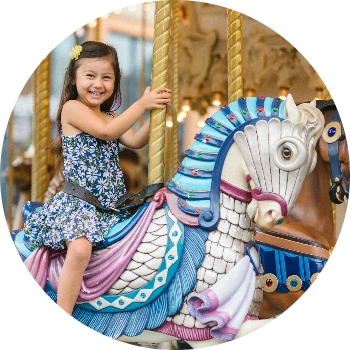 child having fun riding on the carousel