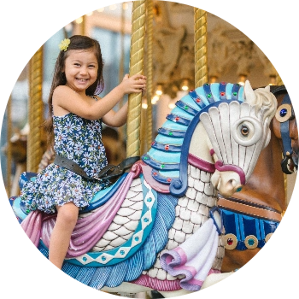 child having fun riding on the carousel