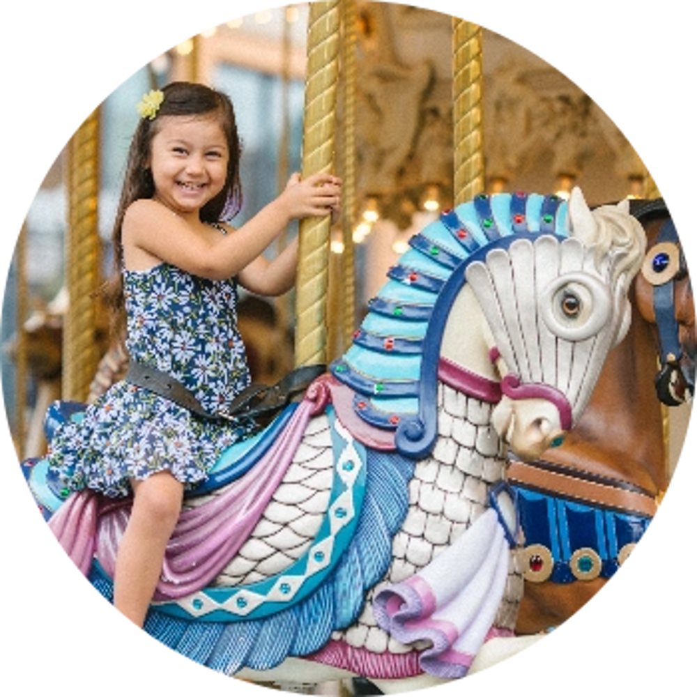 child having fun riding on the carousel